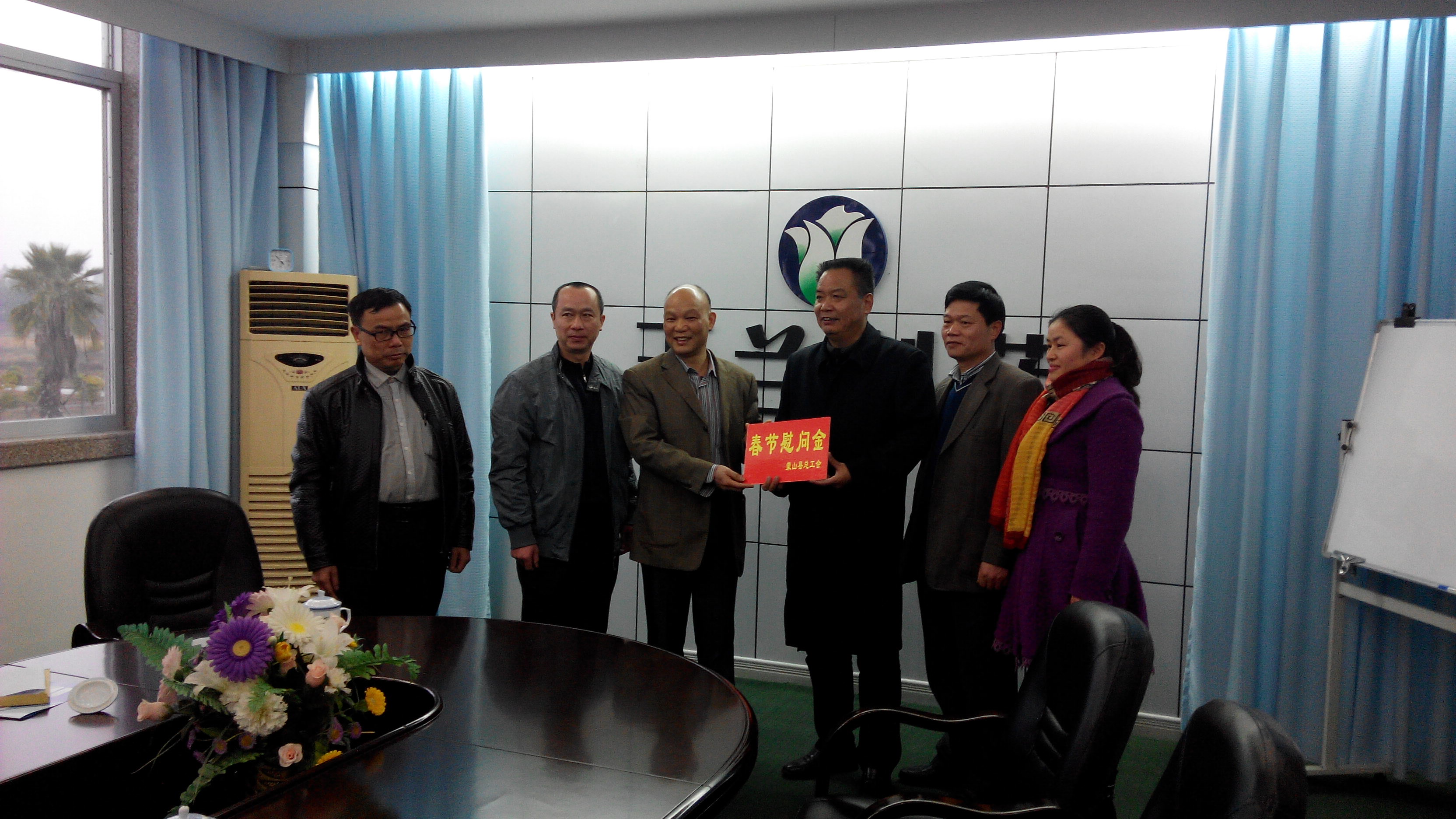 1月28日，梧州市總工會(huì)副主席謝海益帶隊(duì)到蒙山開展春節(jié)前慰問(wèn)活動(dòng)。圖為市總工會(huì)謝副主席給玉蘭制藥公司送上春節(jié)慰問(wèn)金。--